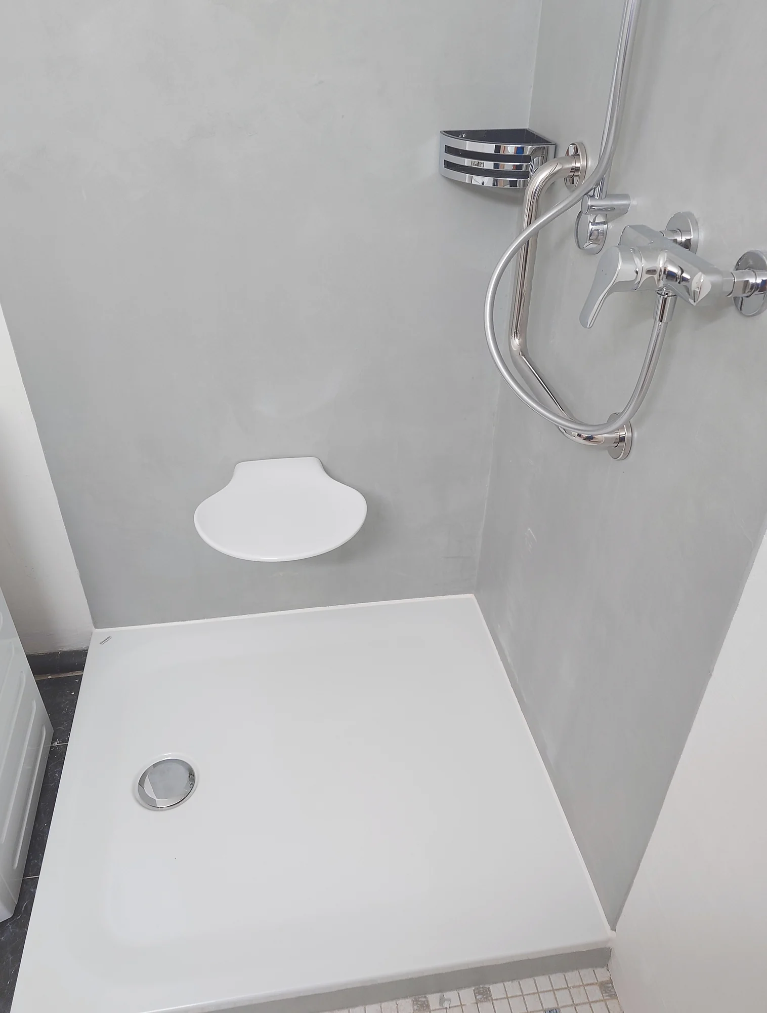 Dusche mit Handbrause und weisser Duschfläche